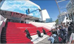  ?? REUTERS ?? Workers install the red carpet in front of the main entrance of the Festival Palace on the day of the opening ceremony of the film festival, on Tuesday.