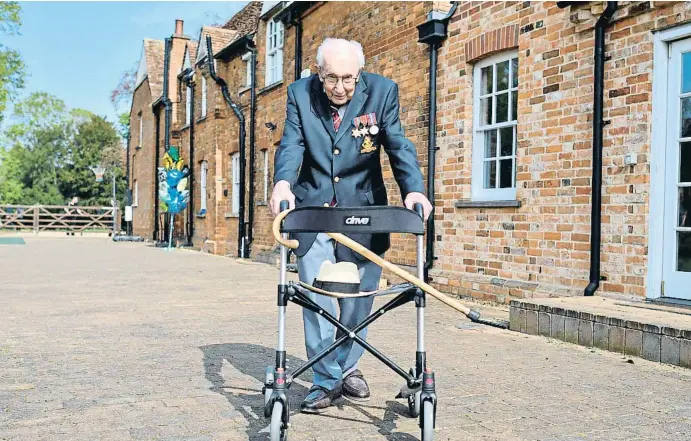  ?? JUSTIN TALLIS / AFP ?? Tom Moore, con su andador en el patio de la casa familiar en Marston Moretaine, a cien kilómetros al norte de Londres, el pasado 16 de abril