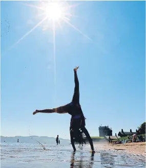  ??  ?? A sun-seeker does a cartwheel on Broughty Ferry beach.