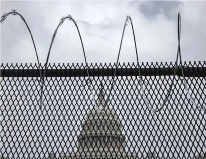  ?? SAMUEL CORUM/GETTY IMAGES ?? Razor wire is seen Friday after being installed on a fence surroundin­g the grounds of the U.S. Capitol.