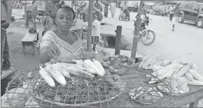  ??  ?? A woman roasts corn at a market in Nigeria. (Photo: thesheet.ng)