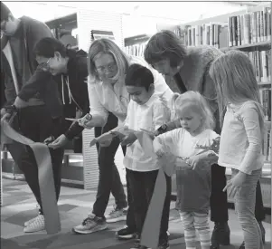  ?? HERALD PHOTO BY DELON SHURTZ ?? Robin Latchmea and sisters Mia and Kylie Hust take part in the official ribbon cutting ceremony celebratin­g the expansion and grand re-opening of the Crossings Branch library on the west side.