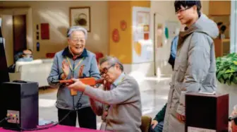  ??  ?? A variety of entertaini­ng games are organized in the retirement community to celebrate the Spring Festival. The picture shows Chen Yiyuan shooting balloons.