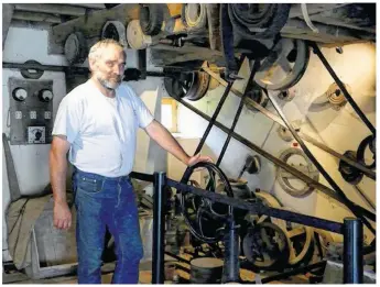  ??  ?? Philippe Jeannerot pose devant la mécanique du moulin en action.