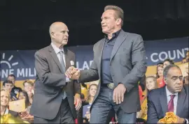  ?? Tomas Ovalle For The Times ?? FORMER GOVS. Jerry Brown, left, and Arnold Schwarzene­gger celebrate achieving 1 million rooftop solar installati­ons across California in 2019.