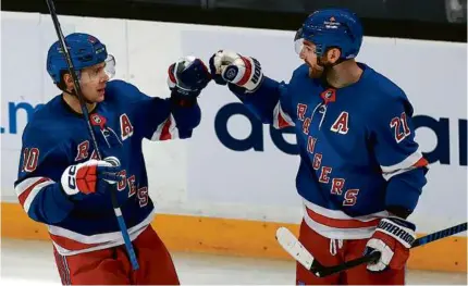  ?? JOHN TLUMACKI/GLOBE STAFF ?? Artemi Panarin (left) bumped into Barclay Goodrow after finishing his hat trick for the Rangers.