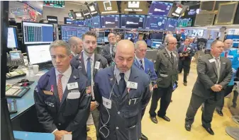  ?? RICHARD DREW/AP ?? Traders at the New York Stock Exchange observe a moment of silence to honor former President George H.W. Bush on Monday.