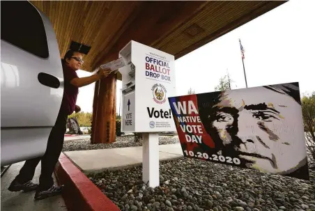  ?? Elaine Thompson / Associated Press 2020 ?? Lummi Nation member Karen Scott casts her ballot in a drop box in 2020 on the tribe’s reservatio­n near Bellingham, Wash.