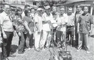  ??  ?? JOACHIM (kanan) menyampaik­an sebuah mesin pemotong rumput kepada wakil penduduk Kg Singgaron.