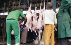 ?? A butcher processing slaughtere­d rams at an abbatoir ??