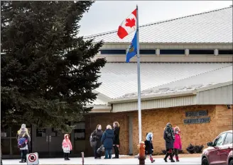  ?? Herald photo by Ian Martens ?? Students, staff and parents make their way in front of the entrance to École Nicholas Sheran Monday at the end of the school day. @IMartensHe­rald