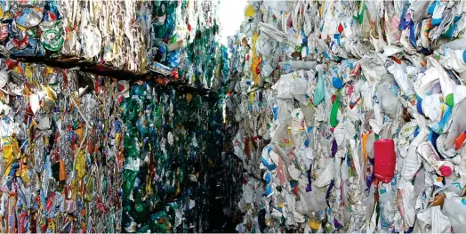  ?? ?? Actuelleme­nt, seules deux sortes de plastiques sont correcteme­nt recyclés (triés et valorisés, c’est-à-dire rapportant de l’argent) dans les centres classiques, les PET et les
PEHD - grosso modo les bouteilles d’eau et de soda, et les flacons (de lessive, de shampoing, par exemple). Photo d’illustrati­on : stockage de bouteilles et flacons plastiques triés et compressés dans un centre de tri classique près de Laval, en octobre 2011. (Crédits : Reuters)