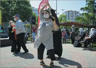  ?? UMIT BEKTAS / REUTERS ?? Seniors in Istanbul, Turkey, dance in a park on Sunday as people over 65 have been exempted from the ongoing curfew in the country for six hours, amid the COVID-19 outbreak.