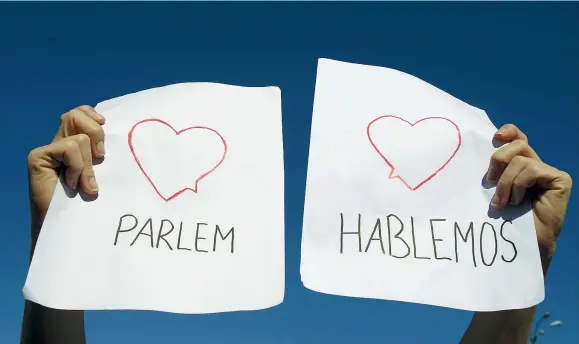  ??  ?? Due lingue Un’immagine scattata ieri a Madrid: dalla capitale a Barcellona, migliaia di persone hanno sfilato al doppio grido «Parlem?» (in catalano) e «Hablamos?» (in castiglian­o): «Parliamo?». Chiedono che si riannodi il dialogo tra la Catalogna e il...