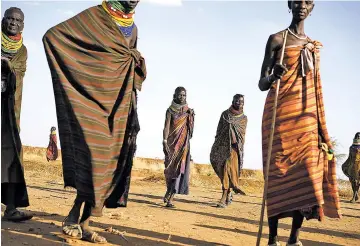  ?? JOAO SILVA/THE NEW YORK TIMES ?? Village women return to their homes Feb. 5 in Kakuma in northern Kenya, an always-arid area that has become hotter and drier with the onset of climate change. Four severe droughts have walloped the area in the last two decades, pushing millions of the...