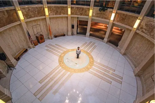  ??  ?? ABOVE: Anna Anaya stands in the Rotunda on Friday. Anaya is responsibl­e for managing the schedule for the Rotunda during the Legislativ­e session.