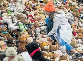  ?? /AFP ?? Solidarity: A child places a teddy bear on the steps of Konzerthau­s in Berlin on Thursday. The humanitari­an aid group World Vision placed 740 teddy bears on the steps of the landmark to draw attention to the plight of the 740,000 Syrian children...