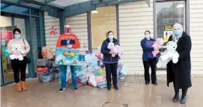  ??  ?? Joe Elms (in red jumper) delivers gifts with Lauren Elms (left) to staff at the children's ward at Wexham Park Hospital. Ref:133247-5