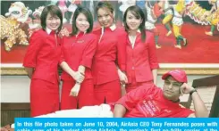  ??  ?? In this file photo taken on June 10, 2004, AirAsia CEO Tony Fernandes poses with cabin crew of his budget airline AirAsia, the region’s first no-frills carrier, at the launch of its first service to Macau. — AFP