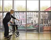  ??  ?? A patient walks past city canal prints at an Amsterdam care center. While some believe calm environmen­ts help dementia patients cope better, evidence of the effectiven­ess is hard to come by, in part because the condition has no cure.