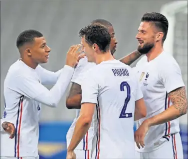  ??  ?? Mbappé, Pavard y Kimpembe felicitan a Giroud tras marcar a Bulgaria el pasado martes.