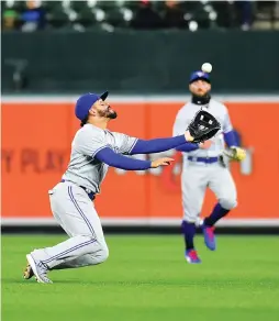  ?? (Reuters) ?? TORONTO BLUE JAYS second baseman Devon Travis (left) dives to make a catch on a ball hit by the Baltimore Orioles’ Tim Beckham (not pictured) in the fifth inning of the Jays’ 2-1 road victory over the Orioles on Tuesday night.