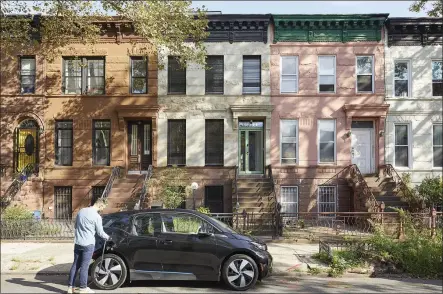  ?? EMILY GILBERT — THE NEW YORK TIMES ?? An electric car owner charges his vehicle in New York City. For city dwellers who would love to own an electric vehicle, the biggest hurdle might be keeping it juiced up without a garage or other convenient charging stations.