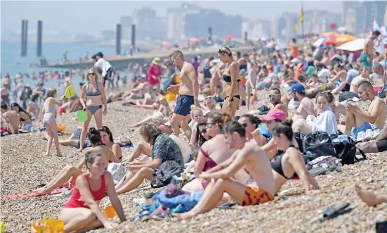  ??  ?? Beachgoers in Brighton. The overload on the NHS last month was highly unusual because the summer is usually the service’s quietest period.