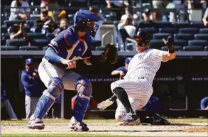  ?? Dustin Satloff / Getty Images ?? The Yankees' Aaron Judge slides safely into home during the eighth inning on Monday against the Rangers.