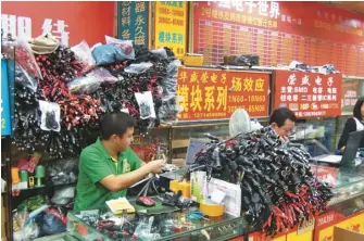  ??  ?? 華強北「中國電子第一街」目前面臨艱難轉型。（特派記者蔡敏姿／攝影） 明通數碼城一美妝店舖­的工作人員，正在整理即將發出去的­貨品。