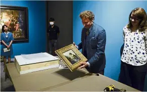  ?? — AFP ?? Exquisite work: Kaplan showing Johannes Vermeer’s ‘ Young Woman Seated at a Virginal’ to the media. The painting will be displayed as part of the Masterpiec­es from The Leiden Collection exhibition at China’s National Museum in Beijing.