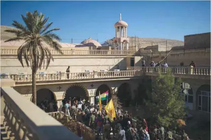  ??  ?? BASHIQA, Iraq: Christians march carrying a cross during a ceremony in the Saint George’s church yesterday. —AP