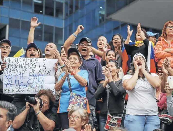  ??  ?? ► Un grupo de personas participa en una manifestac­ión contra el gobierno de Nicolás Maduro, ayer en Caracas.