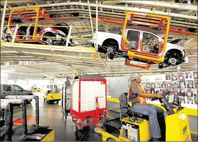  ?? AP file photo ?? Pickup frames are suspended on the assembly line at the Nissan Canton Vehicle Assembly Plant in Canton, Miss., in April 2016. An employee vote at the plant on United Auto Worker representa­tion is set for Aug. 3 and Aug. 4.