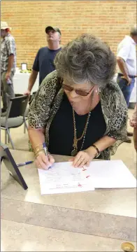  ?? ELISHA MORRISON/THE Saline Courier ?? Supporter Nancy Christian signs in the event guest book.