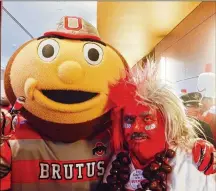  ??  ?? Brutus Buckeye, the Ohio State mascot, buddies up to former Urbana councilman and retired teacher Larry Lokai, a 76-year-old superfan and OSU graduate known as “Buckeyeman.”
