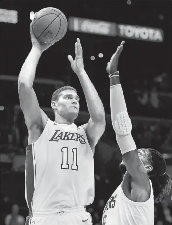  ?? Harry How Getty Images ?? BROOK LOPEZ, scoring over the Clippers’ Montrezl Harrell during an exhibition, has averaged 18.6 points a game in his career, and his three-point shooting will be important to the Lakers’ offense.