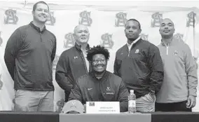  ?? KATHERINE FOMINYKH/BALTIMORE SUN MEDIA GROUP ?? Archbishop Spalding’s Jahmeer Carter signed with Virginia during early signing, with coach Kyle Schmitt, assistants Chuck Markiewicz, Troy Gibson and Tyrone Forby.