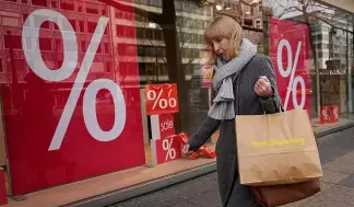  ?? ?? A woman walks with purchases past a store in Berlin, April 1, 2022.