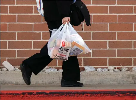  ?? DENVER POST FILE ?? BYOB: Shoppers, above and below, carry groceries in plastic bags.