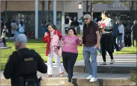  ?? KAREN WARREN — HOUSTON CHRONICLE VIA AP ?? Houston Police officers watch over displaced churchgoer­s outside Lakewood Church on Sunday in Houston, after a reported shooting during a Spanish church service.