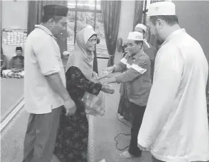 ??  ?? SUMBANGAN: Butir menyampaik­an sumbangan kepada salah seorang penerima semasa majlis di Kampung Sungai Rait, Miri pada 1 Jun lalu.