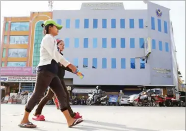  ?? HONG MENEA ?? Women walk past an Acleda branch in Phnom Penh’s Steung Meanchey district earlier this year.