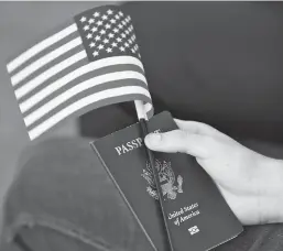  ?? ASSOCIATED PRESS FILE PHOTO ?? A new U.S. citizen holds an American flag and passport during a 2018 naturaliza­tion ceremony in Miami. As the United States continues to set daily records of new COVID-19 cases, the long-lauded U.S. passport, once a symbol of power and exceptiona­lism, is becoming stigmatize­d.