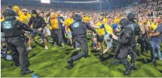  ?? FOTO: IMAGO ?? Braunschwe­iger Chaoten stürmen nach dem Abpfiff das Spielfeld, die Polizei rückte aus.