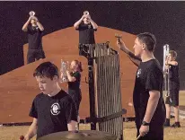  ?? above ?? During the Queen City High School Band’s show, the chimes are played by Seth Alexander, while Colton Henry and Adam Bowen sound out their trumpets. Connor McGee, Jessica Clark and Colton Cromeans move to new positions.