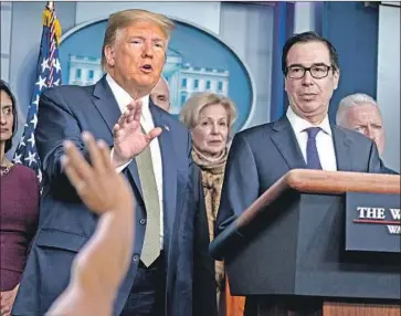  ?? Evan Vucci Associated Press ?? PRESIDENT Trump speaks during a media briefing with the coronaviru­s task force at the White House on Tuesday. He is joined by Treasury Secretary Steven T. Mnuchin, right, who announced the tax extension.