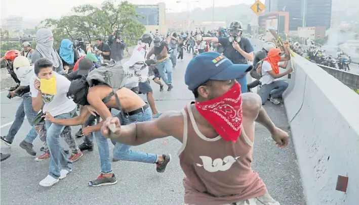  ?? AP ?? Piedras. Manifestan­tes opositores se enfrentan con miembros de las fuerzas de seguridad venezolana­s. La oposición realizó ayer un “Gran Plantón Nacional” contra el gobierno.