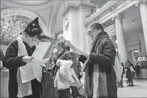  ?? MARY ALTAFFER / AP ?? Visitors to the Metropolit­an Museum of Art inspect the map of the museum after purchasing a ticket.