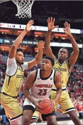  ?? AP - Timothy D. Easley ?? Louisville’s Steven Enoch (23) is defended by Georgia Tech’s James Banks III (1) and Moses Wright during the second half of Wednesday’s game.